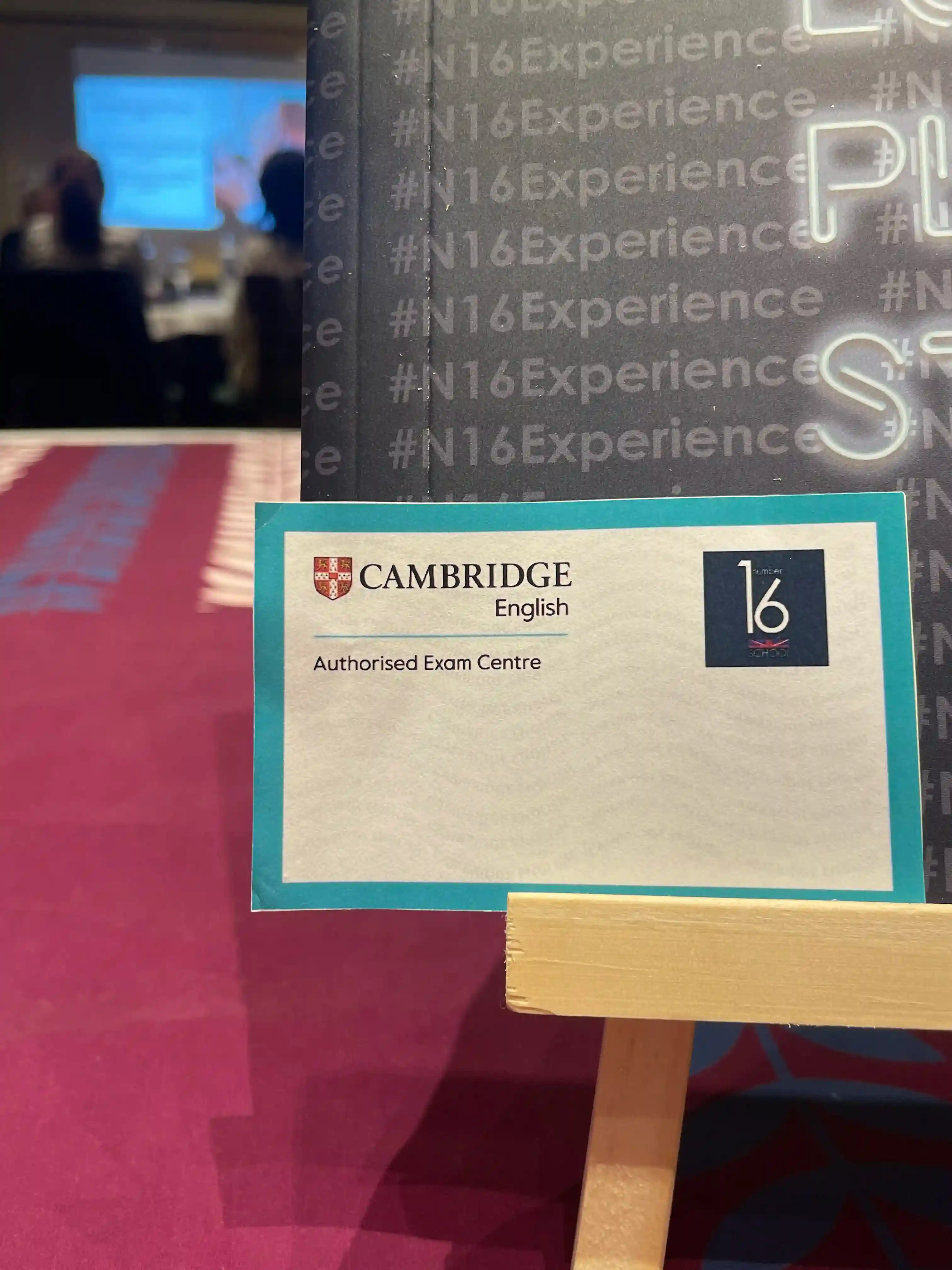 Alumnos de Number 16 School con el cartel de próximas convocatorias de Cambridge